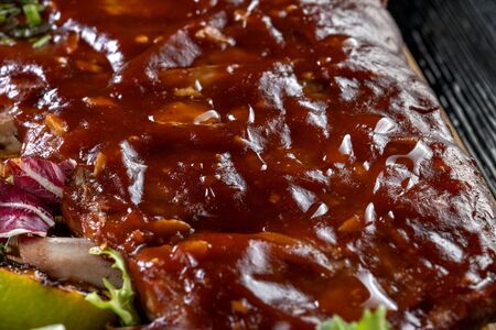 Pork ribs with sauce laid out on a wooden board.の写真素材