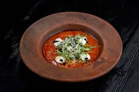 Tomato soup with arugula and grated cheese.の写真素材
