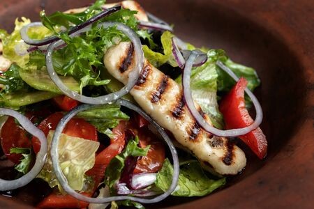 Fresh salad with grilled cheese, tomatoes, olives, lettuce  arugulaの写真素材