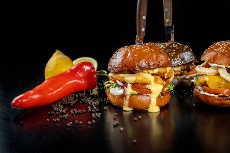 Three burgers with nipples, onion rings, beef cutlet and chicken nuggets.の写真素材