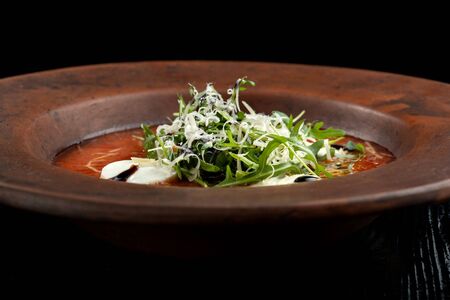 Tomato soup with arugula and grated cheese.の写真素材