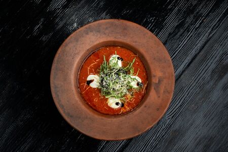 Tomato soup with arugula and grated cheese.の写真素材
