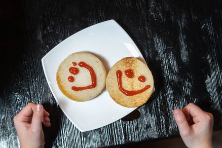 Two slices of bread with painted faces with ketchup.