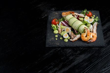 Plate with appetizers, shrimp, cucumber, eggs, salad.の写真素材