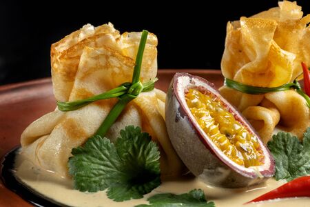 Pancakes stuffed with soyce and hot pepper. With delicious granadilla.の写真素材