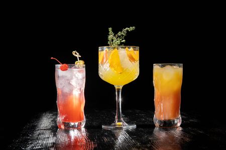 Three alcoholic cocktail with juice garnished with cherry and jalapeno pepper planted for a long time.の写真素材