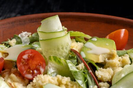Green salad with couscous, avocado and tomato.の写真素材
