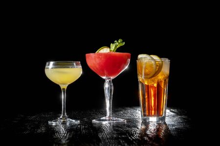Three cocktails, Strawberry daiquiri, Long island and daiquiri on black background.の写真素材
