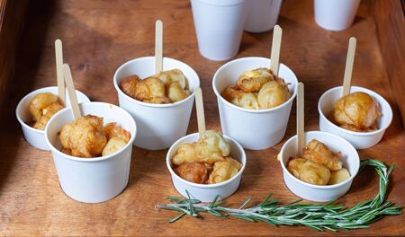 Garlic, potato balls in paper cups. Decorated with rosemary.の写真素材