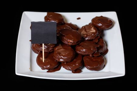 Chocolate covered snack cakes on a white dish. Delicious homemade cookies, a plate for signature.の写真素材