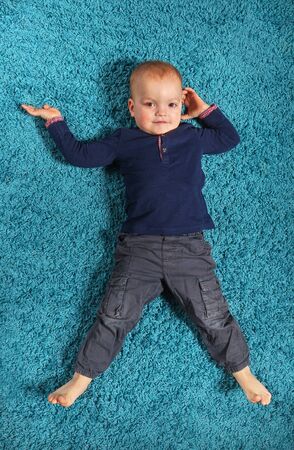 Boy lying on the carpet 2の写真素材