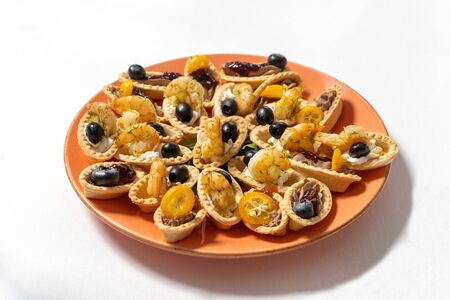 Tartlets with cream cheese, shrimps and black olives, decorated with kumquat.の写真素材