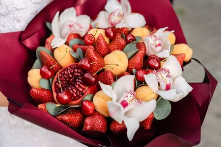 Bouquet of orchids, pomegranates, strawberries, apricots and cherries Top viewの写真素材