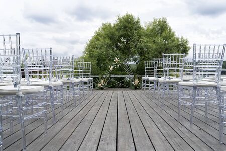 Chiavari chairs are transparent, at a beautiful wedding event. Beautiful wedding arch.の写真素材