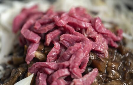 Sliced onions and meat, ingredients for goulash.の写真素材