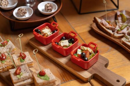 Organic caesar salad in red bowl with caesar dressing. On a vintage wooden board, luxury catering.の写真素材