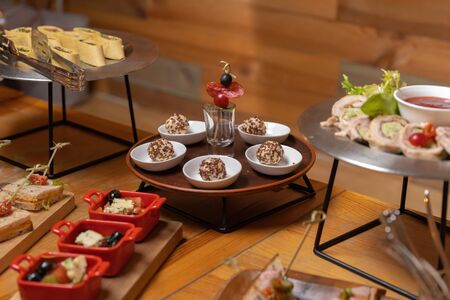 Catering table, beautiful wooden table, warm light. Dear dishes, beautiful layout. Clouse-up.