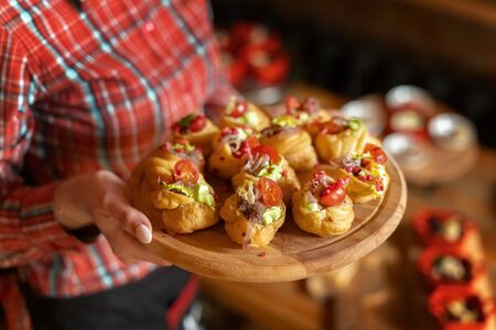 Profiteroles with pate, decorated with green salad, tomato and onion, on a tray.の写真素材