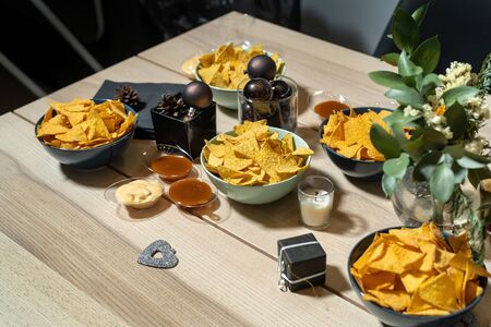A plate of delicious plain nacho tortilla corn chips on a beautiful table. Christmas theme, balls and decorations.の写真素材