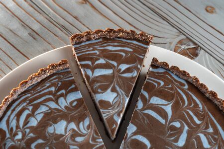 Chocolate cake with nuts, laid on a plate. Beautifully cut piece.