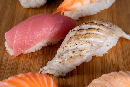 Sushi seared seabass, nearby are other types of sushi. Beautiful bamboo doshka. Delicious food.の写真素材