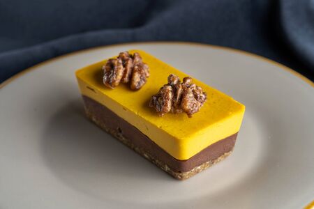 Homemade pumpkin pie with chocolate, and nuts. Decorated with walnuts. Blue background.の写真素材