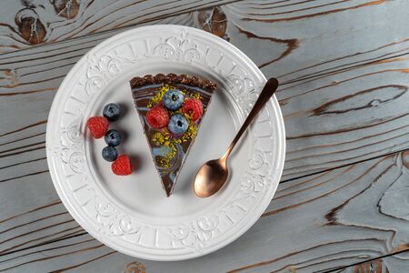 Slice of chocolate cake with nuts, decorated with berries, blueberries and raspberries.の写真素材