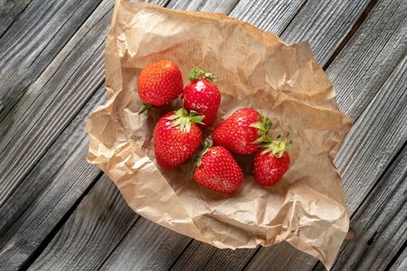 Fresh strawberries laid out on craft paper. Beautiful wooden rustic background.の写真素材