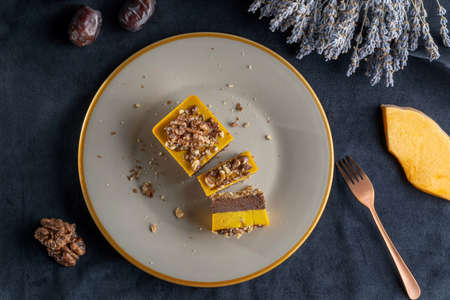 Homemade pumpkin pie with chocolate, and nuts. Sprinkled with walnuts. Laid on a plate. A slice of pumpkin as a decoration.の写真素材