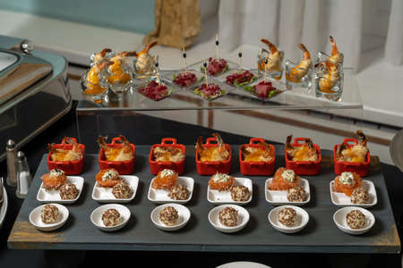 Salmon rolls, with cream cheese and butter, sprinkled with sesame seeds. Nearby are cheese balls in sesame seeds.の写真素材