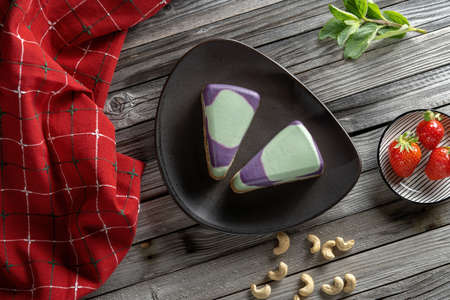 Blueberry cake, lemon, mint. Vegan, lactose free and sugar free. Laid on a pink plate. On a wooden background in rustic style. In the background, strawberries, beautiful fabrics in the decor.の写真素材