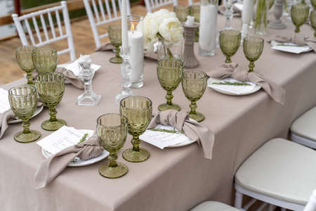 Decorated wedding table, white peonies and feathers. Chiavari chairs are at the table.の写真素材