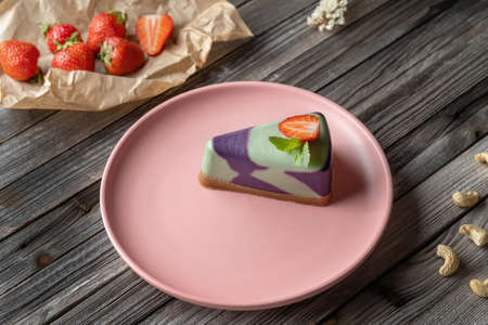 Blueberry cake, lemon, mint. Vegan, lactose free and sugar free. Laid on a pink plate, decorated with strawberries.の写真素材