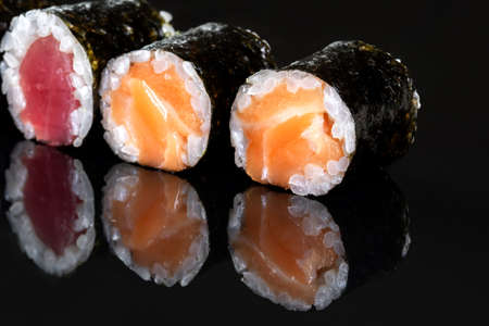 Rolls with salmon, rice, nori, fresh salmon. Several rolls are in one row.の写真素材