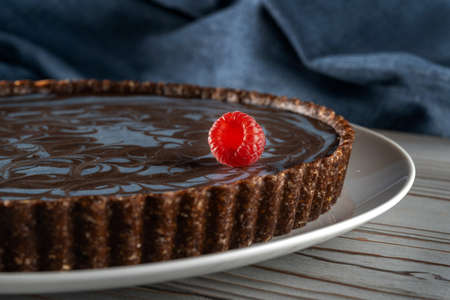 Chocolate cake with nuts, laid on a plate. On the cake lies a beautiful raspberry berry-2.の写真素材