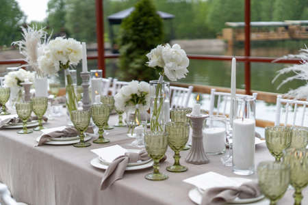 Decorated wedding table, white peonies and feathers. Chiavari chairs are at the table-3.の写真素材