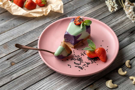 Blueberry cake, lemon, mint. Vegan, lactose free and sugar free. Laid on a pink plate, Ð° small piece is broken off and the structure of the cake is visible.の写真素材
