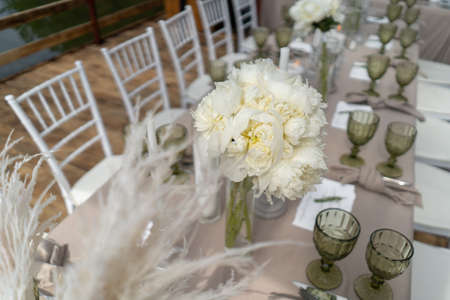 Decorated wedding table, white peonies and feathers. Chiavari chairs are at the table-2.の写真素材