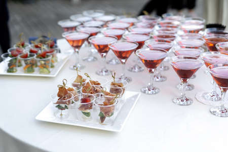 Set of cold snacks, jamon as the main snack. In the background drinks in beautiful glasses.の写真素材