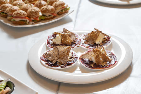 Luxurious catering table. Croutons with cheese and jam, decorated with seeds.の写真素材