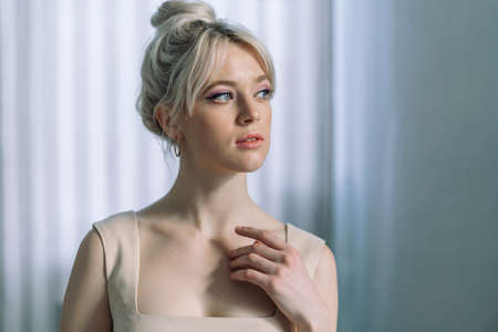 Close up studio portrait of a pretty blonde woman, looking to the side.の写真素材