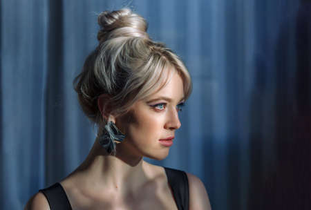 Close up studio portrait of a pretty blonde woman in black top. Clouse-up
