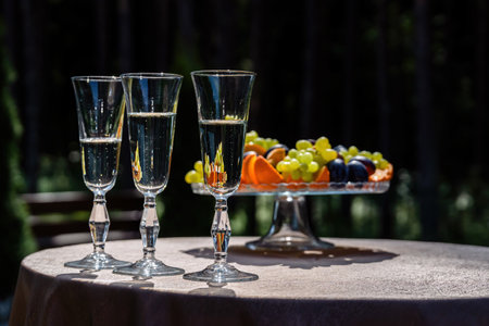 Basket with fruit and glasses with champagne outside.の写真素材