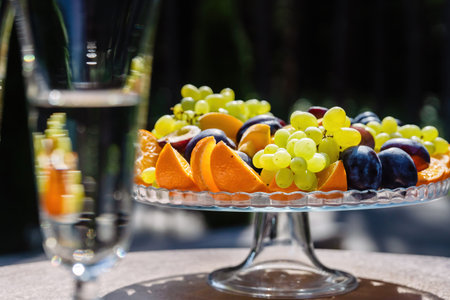 Basket with fruit and glasses with champagne outside.の写真素材