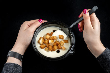 Cream soup with croutons. Delicious mushroom, top view, girl with a spoon.の写真素材