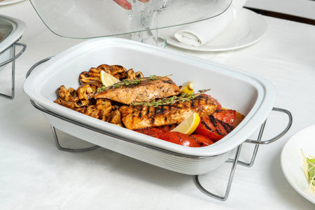 Salmon pieces, champignons, grilled tomatoes in marmite.の写真素材