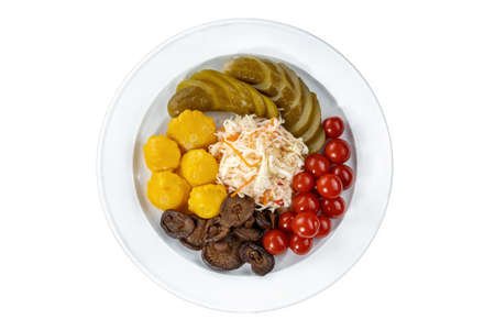 Pickles tomatoes, mushrooms, zucchini and cabbage on plate.の写真素材