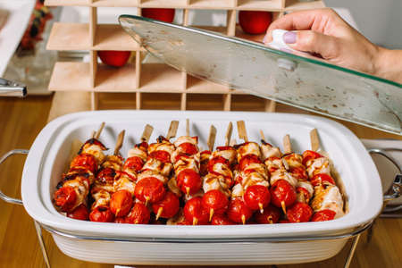 Delicious roasted turkey or chicken kebab skewers meat barbecue on clay dish with tomatoes.の写真素材