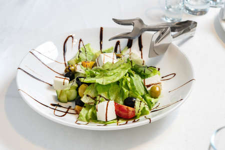 Caesar salad with feta cheese, organic kalamata olives, juicy tomatoes, onion, cucumber and lettuce.の写真素材