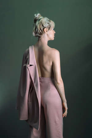 Sexy young blonde looking standing topless with a jacket in his hand. Waist planの写真素材